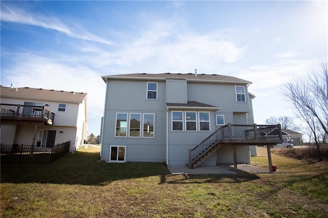 rear view of house featuring a wooden deck and a lawn