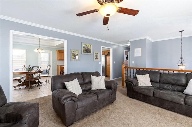 living room with light tile patterned floors, light colored carpet, ornamental molding, and a ceiling fan