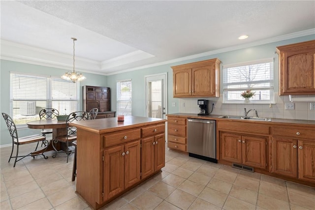 kitchen with visible vents, dishwasher, a tray ceiling, decorative backsplash, and a sink