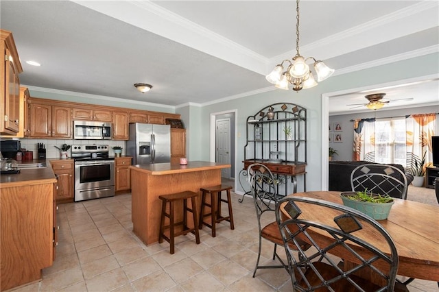 kitchen with a center island, ornamental molding, decorative backsplash, a kitchen breakfast bar, and stainless steel appliances