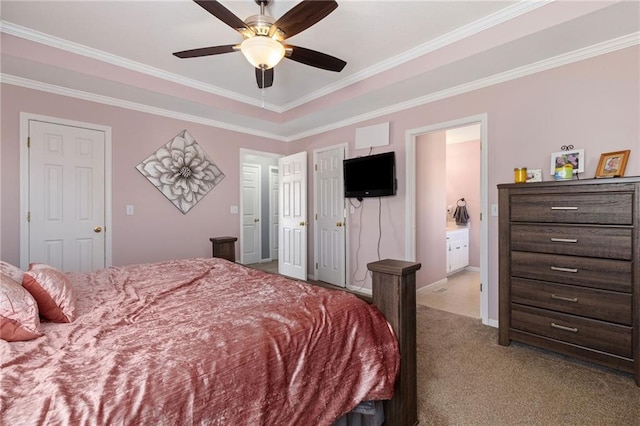 carpeted bedroom with ceiling fan, baseboards, ornamental molding, and ensuite bathroom