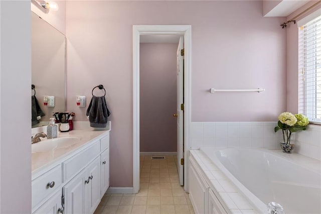 bathroom with visible vents, baseboards, a bath, and vanity