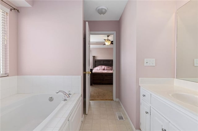 ensuite bathroom with visible vents, ensuite bathroom, baseboards, a bath, and vanity