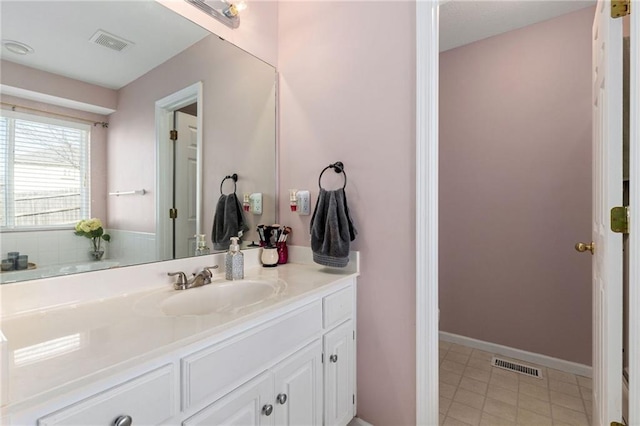 bathroom featuring vanity, baseboards, and visible vents