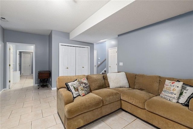 living room featuring light tile patterned floors, stairway, and baseboards