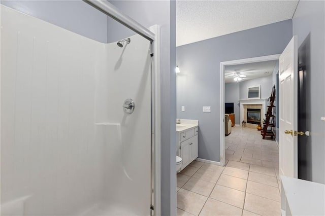 full bathroom with a textured ceiling, a shower stall, a fireplace, and tile patterned flooring