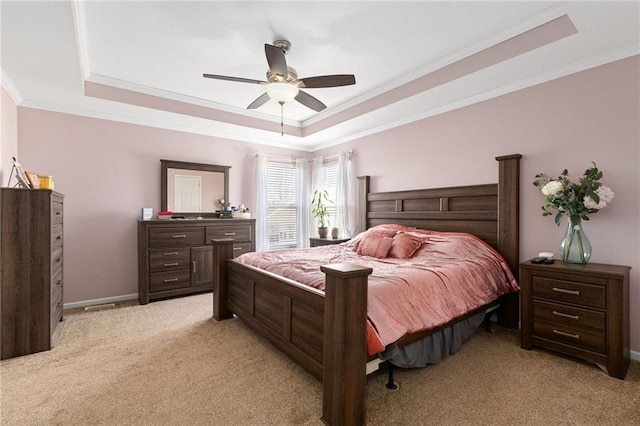 bedroom featuring a tray ceiling, light colored carpet, baseboards, and ornamental molding