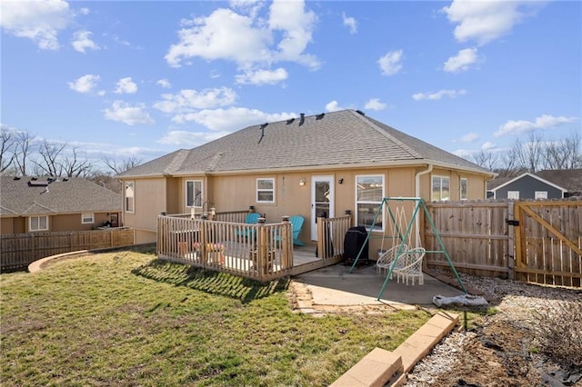 rear view of house featuring a patio, a gate, a fenced backyard, a deck, and a lawn