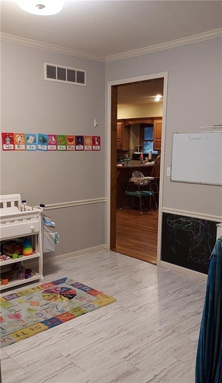 recreation room featuring crown molding and light hardwood / wood-style floors