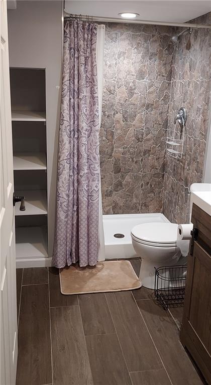 bathroom with vanity, curtained shower, and toilet