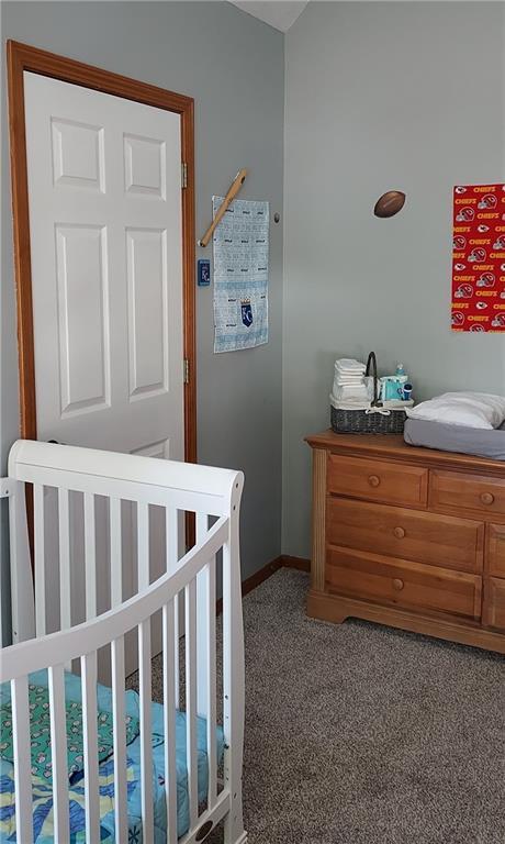 bedroom with a crib and carpet floors