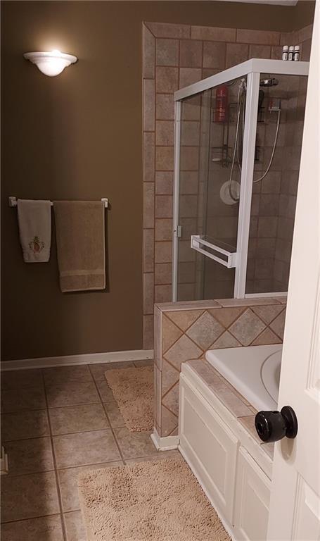 bathroom featuring tile patterned flooring and shower with separate bathtub