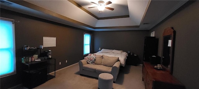 bedroom with ceiling fan, light colored carpet, and a raised ceiling