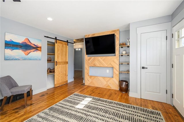 living room featuring wood-type flooring and a barn door