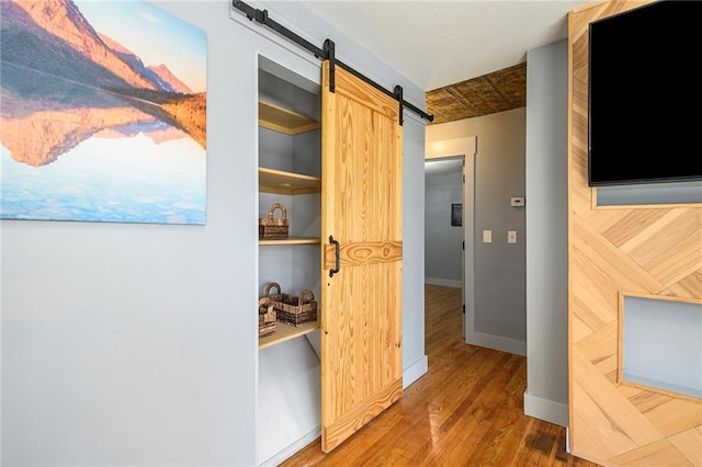 corridor featuring dark hardwood / wood-style floors and a barn door