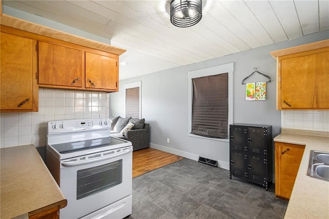 kitchen featuring tasteful backsplash, sink, and electric range