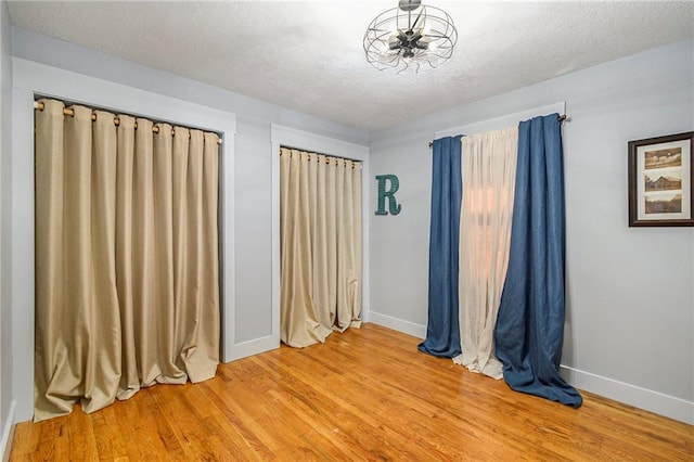 unfurnished room featuring hardwood / wood-style floors and a textured ceiling