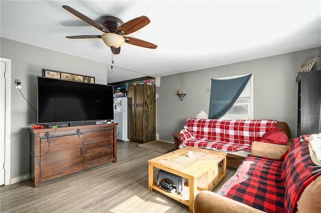 living room featuring hardwood / wood-style floors and ceiling fan