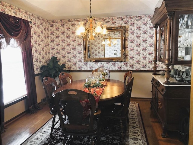 dining room with dark hardwood / wood-style floors and a notable chandelier