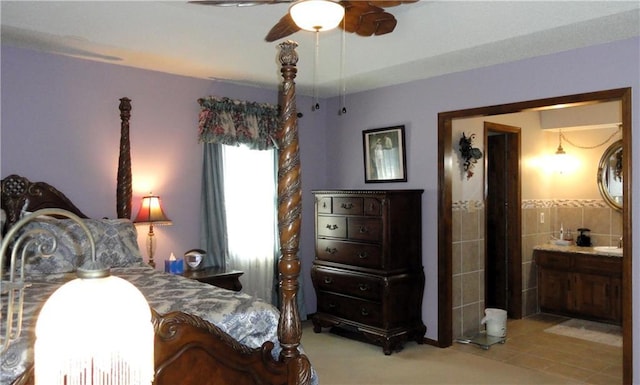 bedroom with ensuite bathroom, tile walls, and ceiling fan