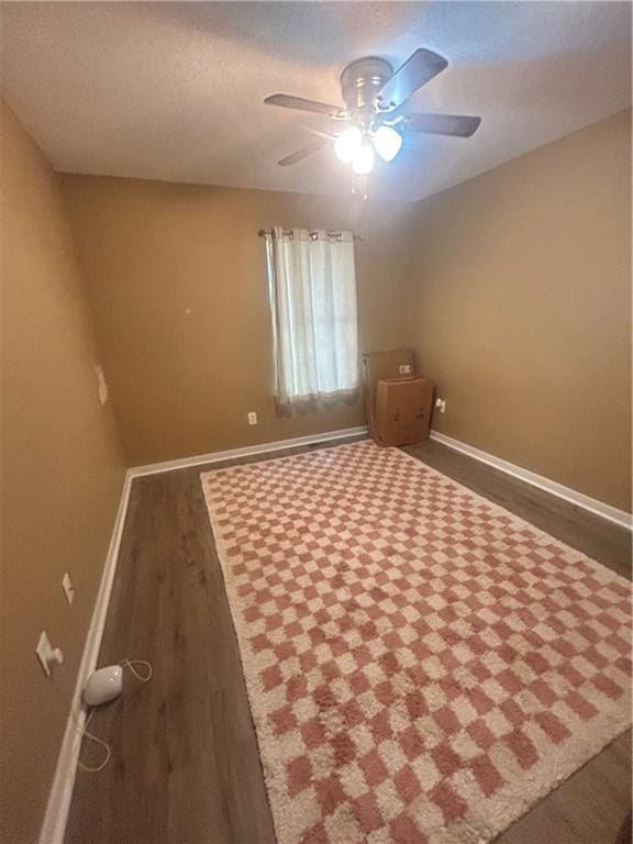 unfurnished bedroom with ceiling fan and dark hardwood / wood-style flooring