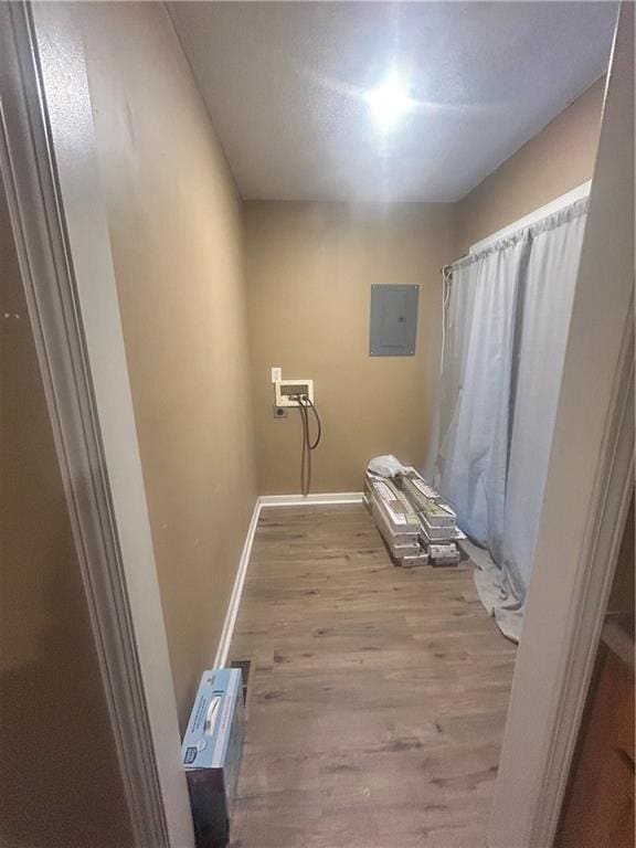 laundry room featuring washer hookup, electric panel, and light hardwood / wood-style flooring