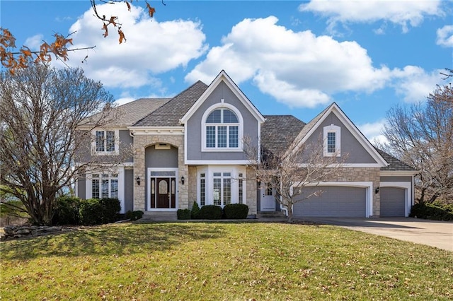 view of front of property with concrete driveway, a front yard, stucco siding, stone siding, and an attached garage