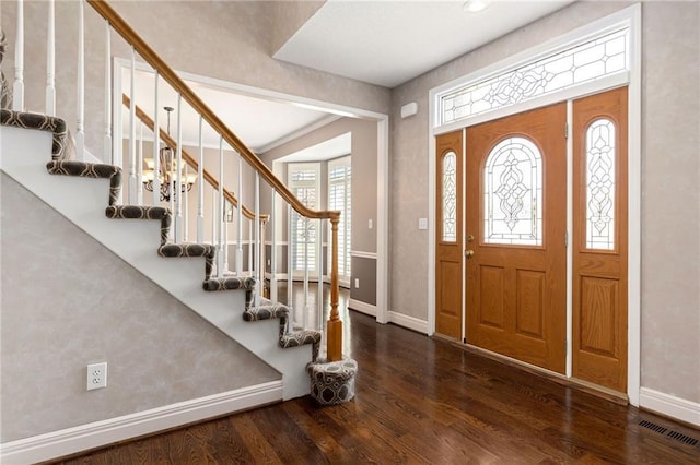 foyer with stairs, wood finished floors, and visible vents