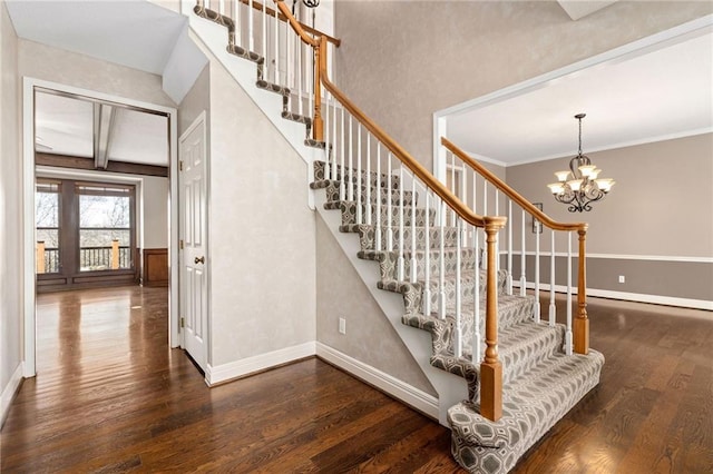 staircase with beamed ceiling, an inviting chandelier, baseboards, and wood finished floors