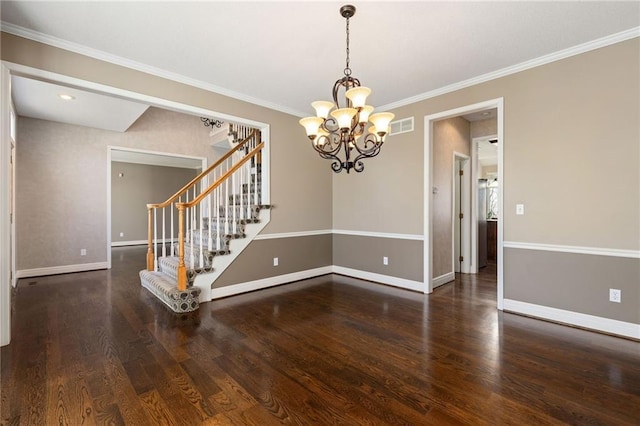 spare room featuring visible vents, baseboards, wood finished floors, and stairs