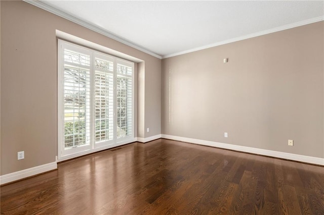 spare room with baseboards, wood finished floors, and crown molding