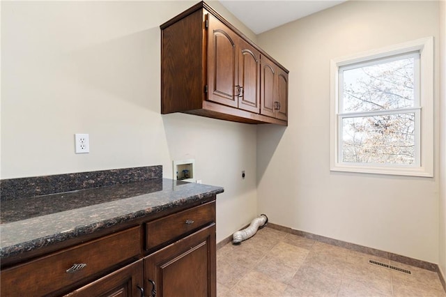 clothes washing area featuring visible vents, cabinet space, hookup for an electric dryer, and baseboards