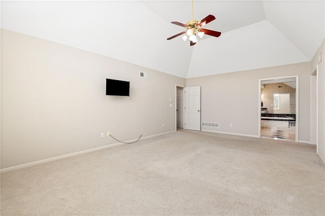 interior space featuring baseboards, visible vents, high vaulted ceiling, ceiling fan, and light carpet