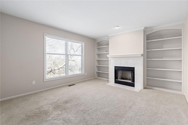 unfurnished living room with visible vents, built in shelves, baseboards, carpet, and a fireplace