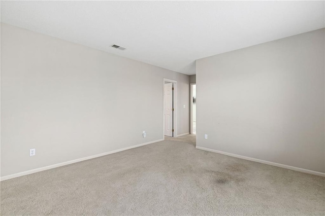 carpeted spare room featuring visible vents and baseboards