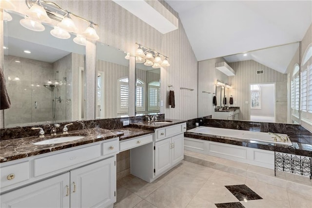 full bathroom with wallpapered walls, vaulted ceiling, a garden tub, and a stall shower