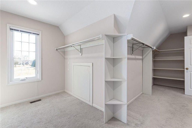 walk in closet with vaulted ceiling, visible vents, and carpet floors