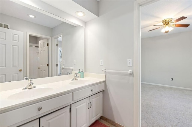 bathroom with a sink, visible vents, double vanity, and a ceiling fan