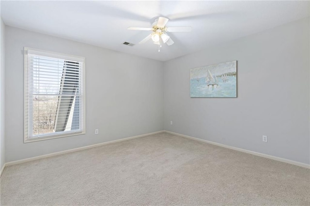 spare room featuring visible vents, carpet flooring, baseboards, and a ceiling fan