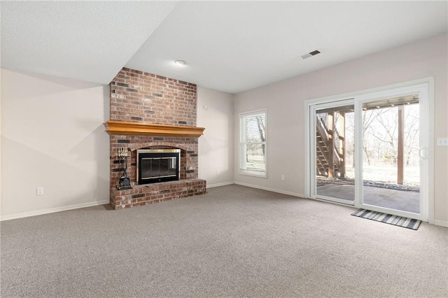 unfurnished living room featuring visible vents, baseboards, a fireplace, and carpet flooring