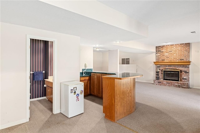 office space featuring a brick fireplace, visible vents, baseboards, and light carpet