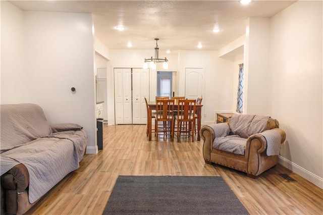 living room with a notable chandelier and light hardwood / wood-style flooring