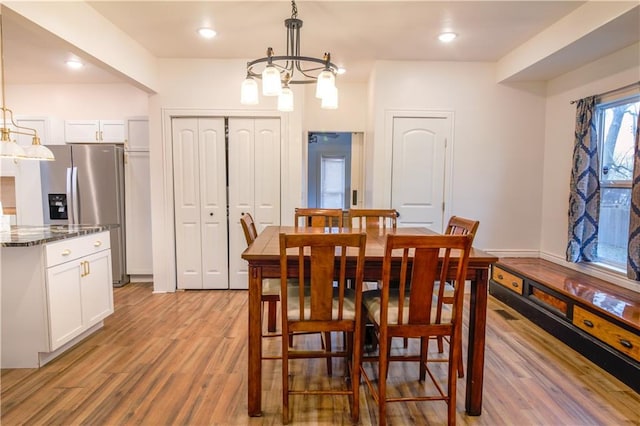 dining area with a notable chandelier and light wood-type flooring