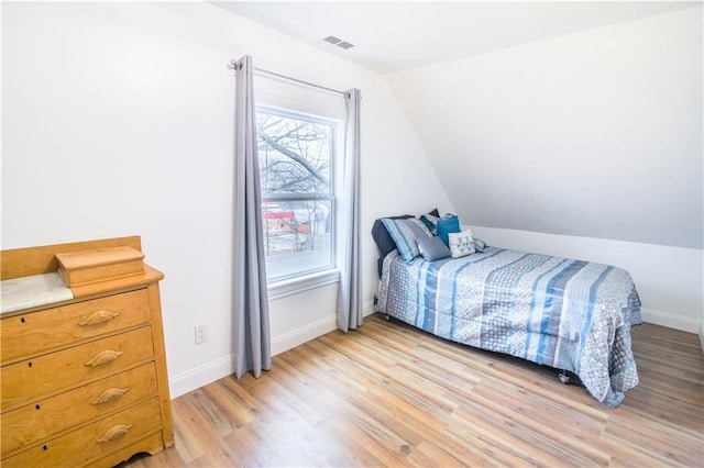 bedroom featuring lofted ceiling and light hardwood / wood-style flooring