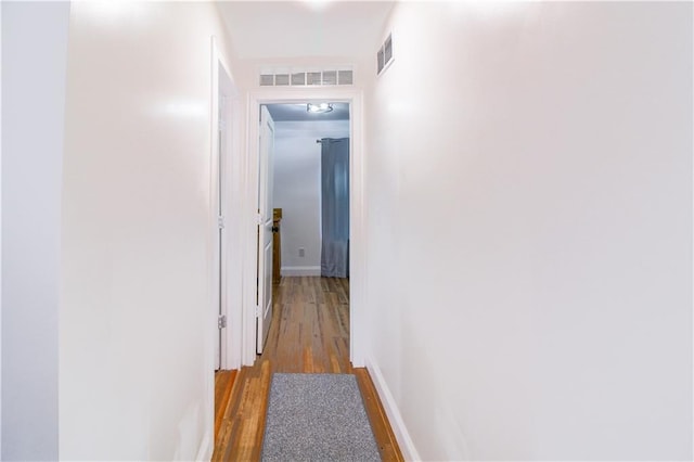 hallway with hardwood / wood-style floors