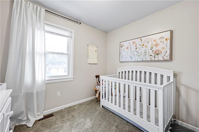 carpeted bedroom with a nursery area and a textured ceiling