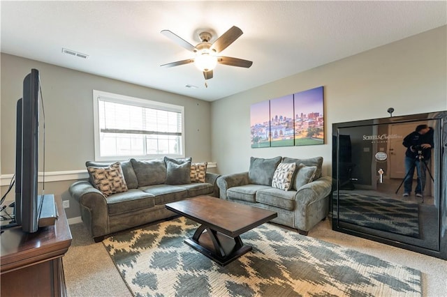 carpeted living room with ceiling fan