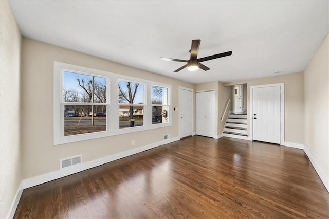 unfurnished living room featuring ceiling fan and dark hardwood / wood-style flooring