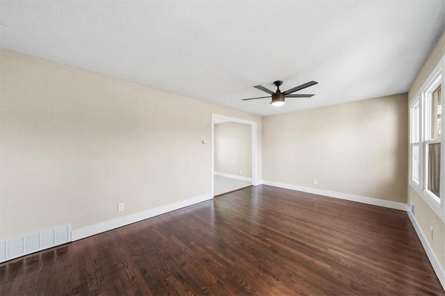 empty room featuring dark wood-type flooring and ceiling fan