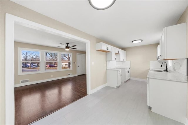 kitchen featuring white cabinetry, sink, and ceiling fan